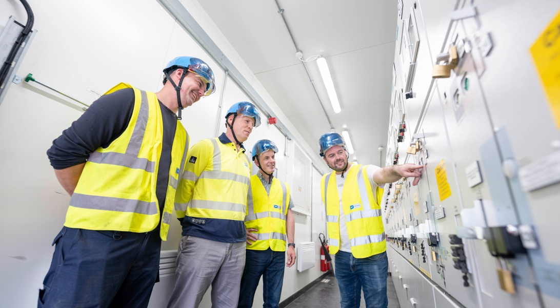 Image of four people assessing substation equipment